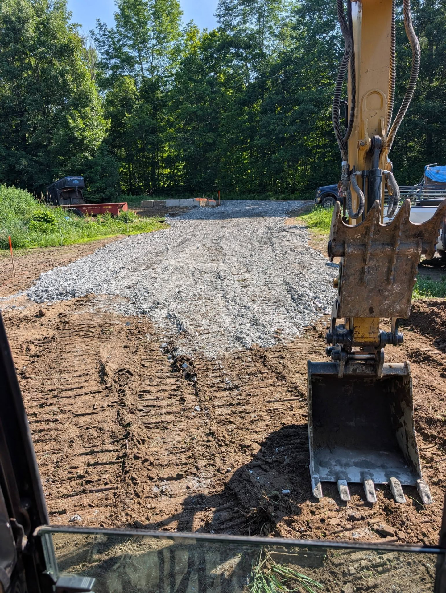 Excavator preparing a gravel driveway in rural Vermont